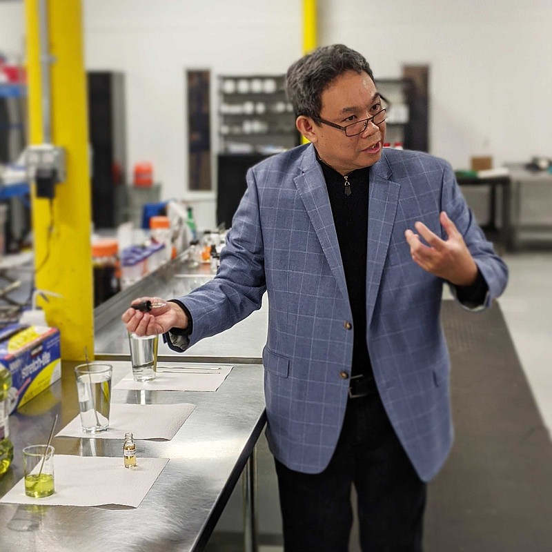 Contributed photo / During a tour and roundtable meeting of stakeholders in the hemp industry, Landrace Bioscience Chief Science Officer Noi Obias demonstrates the water-soluble nature of the CBD oil the company produces.