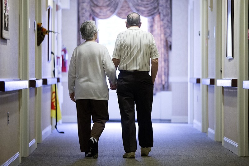 FILE - In this Nov. 6, 2015 file photo, an elderly couple walks down a hall in Easton, Pa. (AP Photo/Matt Rourke, File)



