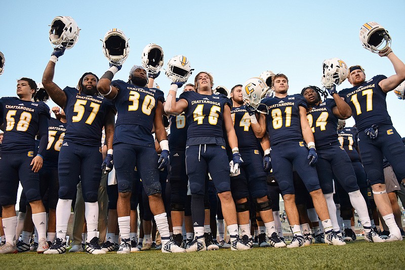 Staff photo by Robin Rudd / UTC football players hold their helmets high as the alma mater is played after the Mocs rallied for a 34-33 victory against The Citadel on Saturday at Finley Stadium.