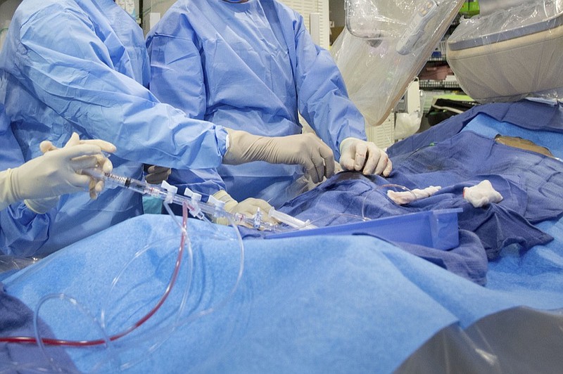 In this Feb. 16, 2017 file photo, surgeons perform a non-emergency angioplasty at Mount Sinai Hospital in New York. Through a blood vessel in the groin, a tube is guided to a blockage in the heart. A tiny balloon is then inflated to flatten the clog, and a mesh tube called a stent is inserted to prop the artery open. (AP Photo/Mark Lennihan)


