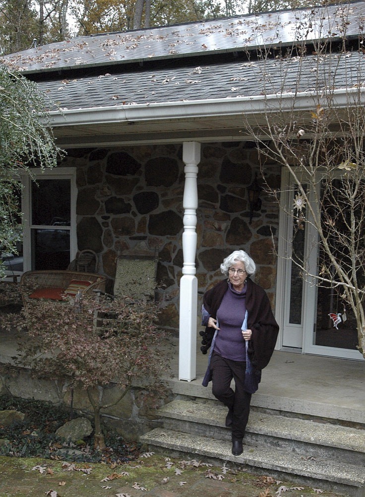 Teresa Thorne walks out of her solar power-equipped home near Springville, Ala., on Thursday, Nov. 14, 2019. Thorne and her husband say they have gotten only limited savings on electricity costs since installing the system because of having to pay a fee to Alabama Power Co. after installing the panels atop their home. (AP Photo/Jay Reeves)


