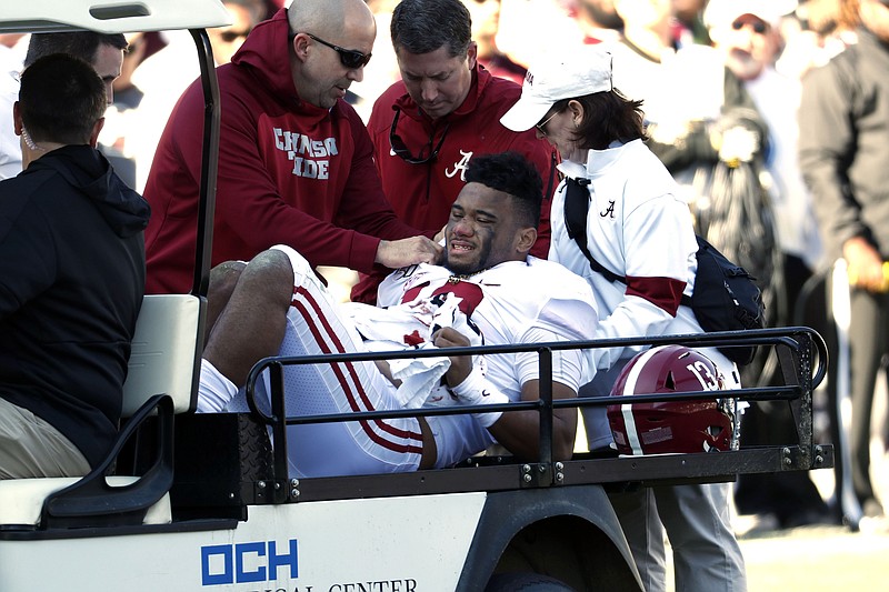 AP photo by Rogelio V. Solis / Alabama quarterback Tua Tagovailoa is carted off the field after dislocating his right hip late in the first half of Saturday's game at Mississippi State.