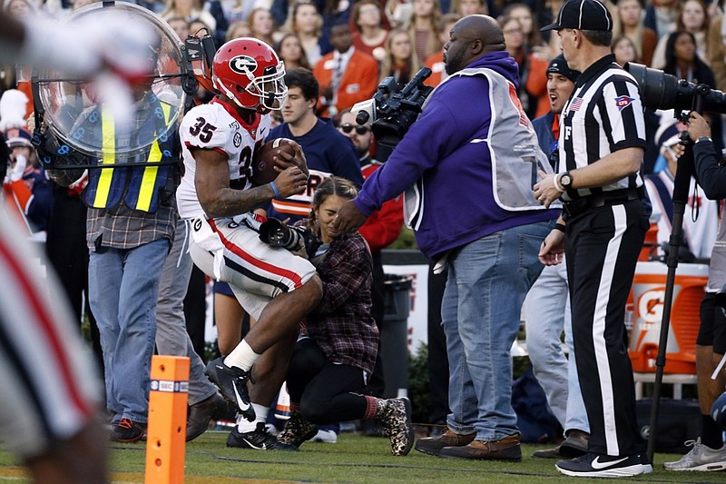 AP photo by Butch Dill / Georgia running back Brian Herrien, after being pushed by an Auburn player, runs into Georgia intern photographer Chamberlain Smith from Ringgold during the first half of Saturday's game at Jordan-Hare Stadium in Auburn, Ala. 