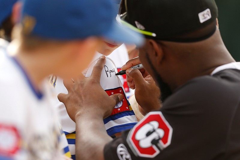 Staff photo by Doug Strickland / Chattanooga player Alfredo Rodriguez signs a fan's jersey during the Lookouts' home baseball game against the Jackson Generals at AT&T Field on Friday, July 5, 2019, in Chattanooga, Tenn.