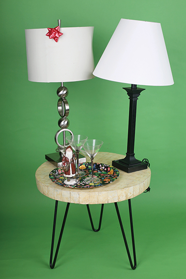 Staff photo by Erin O. Smith / Capiz shell side table ($30), metal serving tray ($1), Santa figurine ($1), martini glasses ($1 each), black table lamp with shade ($7), silver table lamp with shade ($25).