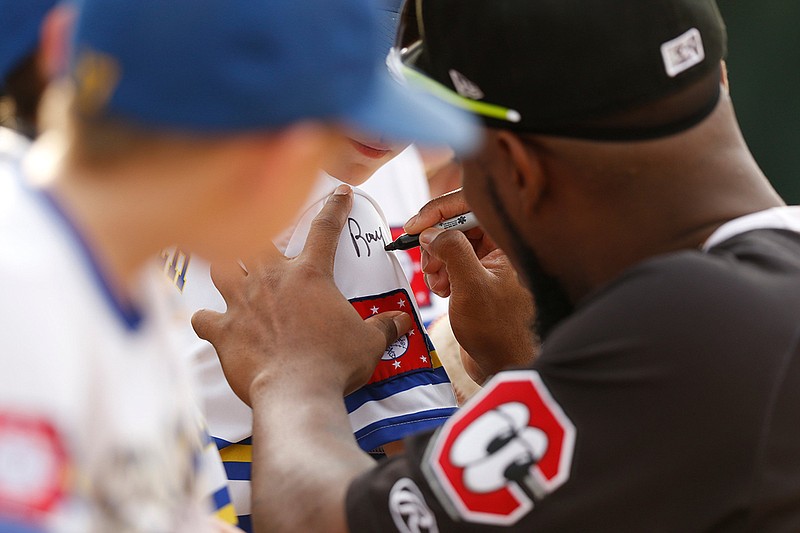 Staff photo / Chattanooga Lookouts player Alfredo Rodriguez signs a fan's jersey at a home game against the Jackson Generals this past July at AT&T Field. The Lookouts and the Generals are two of the minor league clubs in danger of losing their affiliations with the majors.