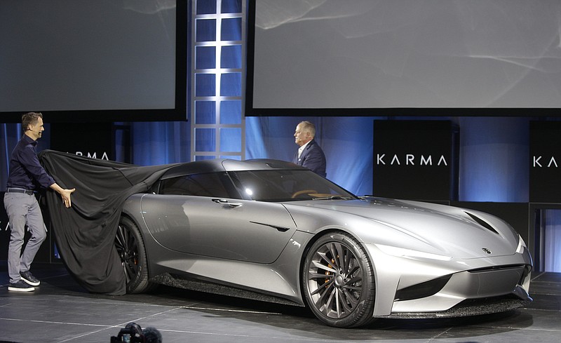 CORRECTS VEHICLE TO KARMA SC2 CONCEPT INSTEAD OF KARMAN VISION SC2  - Karma Automotive Andreas Thurner, Vice President for Global Design and Architecture, left, and Todd George, VP of Platform Engineering at Karma Automotive, unveil the Karma SC2 concept vehicle at the Automobility LA Auto Show in Los Angeles Tuesday, Nov. 19, 2019. (AP Photo/Damian Dovarganes)