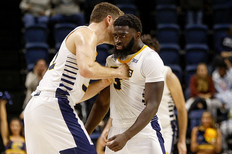 Staff file photo by C.B. Schmelter / UTC's Matt Ryan, left, shoves teammate David Jean-Baptiste in celebration after a 3-pointer during the Mocs' game against Tennessee State on Nov. 9 at McKenzie Arena. Jean-Baptiste scored 15 points for UTC in Wednesday night's loss at Florida State.