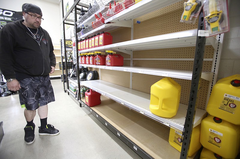 Grass Valley's Dionicio Torres looks at the gas can selection before taking the last 5-gallon gas can on the shelves at B&C Ace Home & Garden Center, in Grass Valley, Calif., Tuesday, Nov. 19, 2019, in preparation of Wednesday's planned public safety power shutdown. (Elias Funez/The Union via AP)