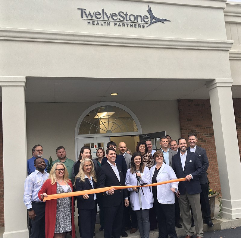Photo by Dave Flessner / TwelveStone Health Partners CEO and state Sen. Shane Reeves, center, appears next to state Rep. Robin Smith Monday to cut the ribbon on new infusion therapy clinic on Shallowford Road.