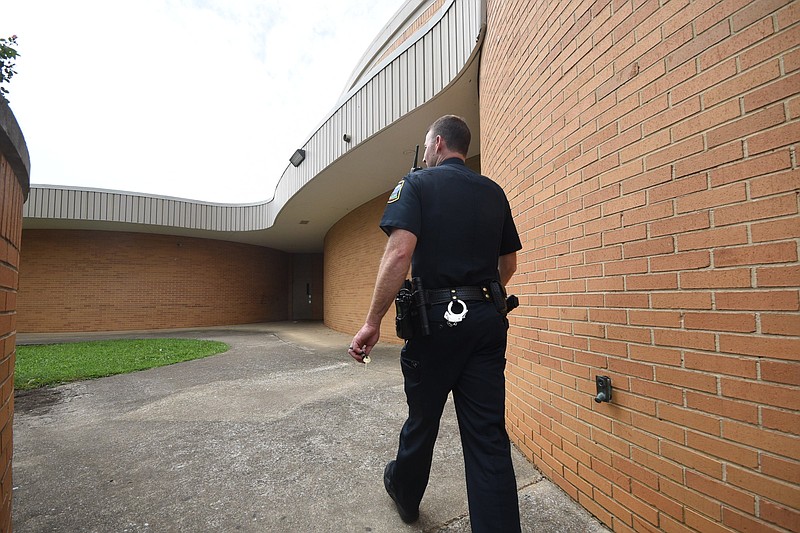 School Resource Officer P. Soyster walks the perimeter outside Central High School Wednesday in Harrison. / Staff file photo by Time Barber