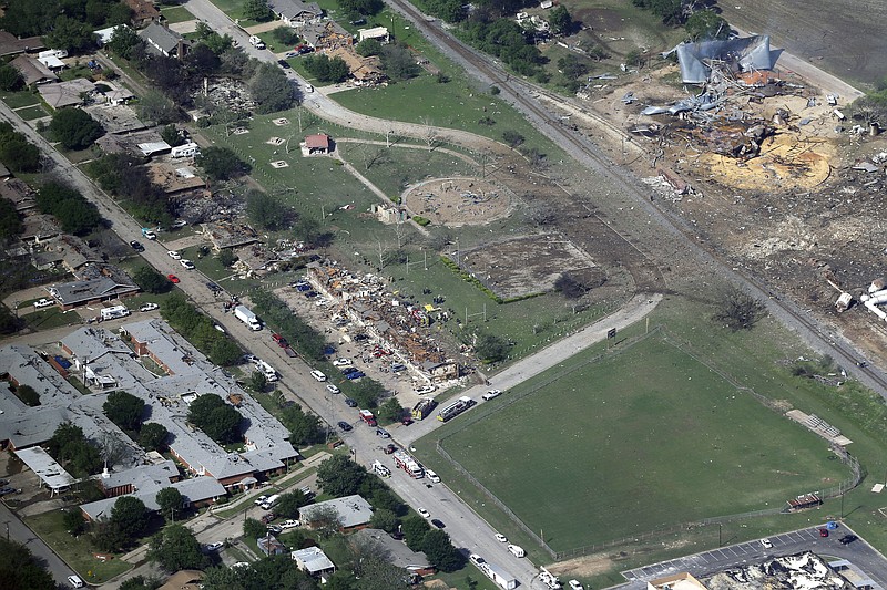 This April 18, 2013 aerial file photo shows the remains of a nursing home, left, apartment complex, center, and fertilizer plant, right, destroyed by an explosion at a fertilizer plant in West, Texas. The Trump administration is scaling back chemical plant safety measures that were put in place after the Texas fertilizer plant explosion in 2013 that killed 15 people. The changes announced Thursday, Nov. 21, 2019, by the Environmental Protection Agency include ending a requirement that plants provide members of the public information about chemical risks upon request. The Obama-era rules followed a fire at the West Fertilizer Co. plant that caused ammonium nitrate to ignite, triggering a massive explosion. (AP Photo/Tony Gutierrez, File)