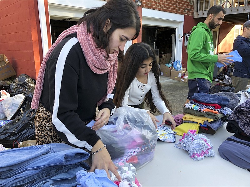 In this Nov. 9, 2019, photo, Beizar Aradini, left, and Delaston Ahmet pack clothing donations in Nashville, Tenn. Members of the Kurdish community and supporters collected the items to send to a camp in Iraq where many Kurds have fled from Syria. Nashville lays claim to the largest diaspora of Kurds in the U.S., and many of them say President Donald Trump betrayed the Kurdish people through the withdrawal of troops from northern Syria. (AP Photo/Jonathan Mattise)