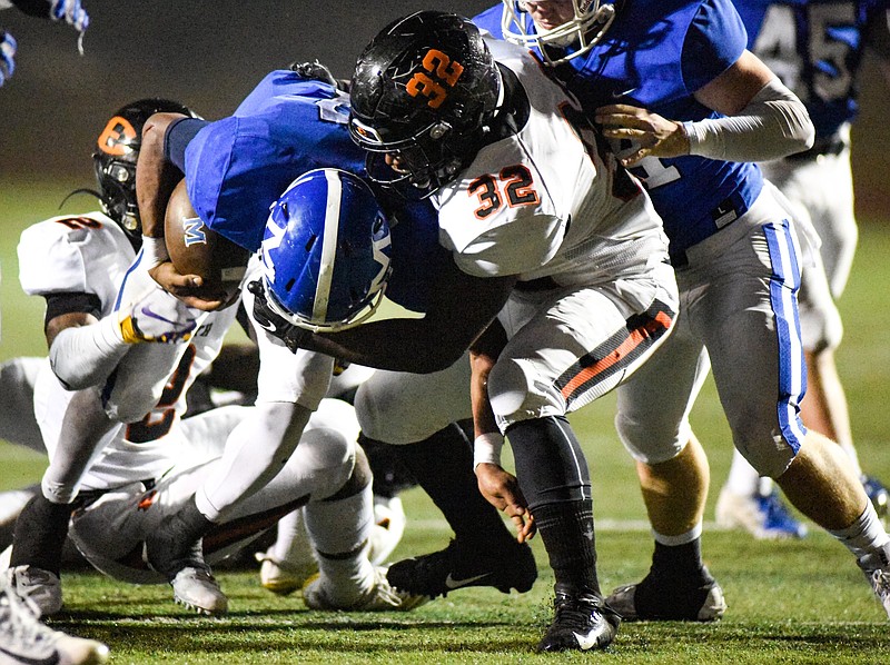 Photo by Cade Deakin /McCallie's DeAngelo Hardy is tackled by Ensworth's Toleo Malone (32) and other Tigers during their teams' TSSAA Division II-AAA semifinal Friday night at Spears Stadium.