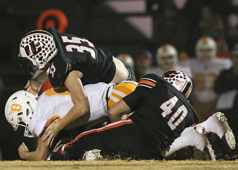 Staff photo by Erin O. Smith / Meigs County's Nolan Pendergrass (35) and Brady Blevens (40) tackle Oneida's Elijah West during a Class 2A quarterfinal Friday night in Decatur, Tenn.