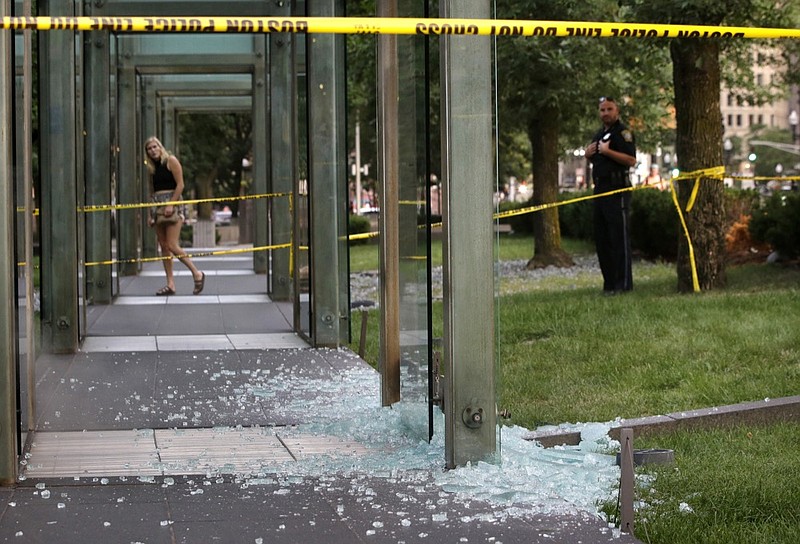 FILE - This Aug. 14, 2017 file photo shows broken glass on the ground near police tape at the New England Holocaust Memorial in Boston. (AP Photo/Steven Senne, File)

