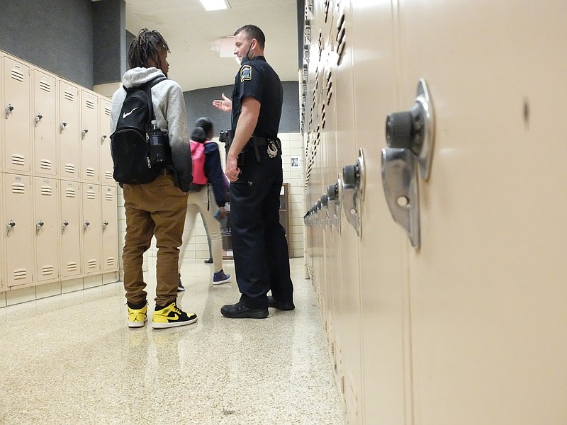 School Resource Officer P. Soyster, right, talks with 12th grade senior Michael Wright in the hallway following the final lunch period Wednesday at Central High School in Harrison. 