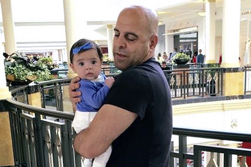 In this June 2016, photo provided by Guila Fakhoury, her father Amer Fakhoury holds his granddaughter, Kira, in King of Prussia, Penn. Amer Fakhoury, a U.S. citizen living in Dover, N.H., went to visit family in his native Lebanon in September after a 20-year absence, and has been jailed there by authorities since. (Guila Fakhoury via AP)