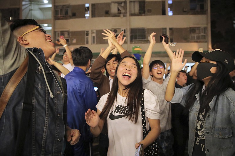 Pro-democracy supporters celebrate after pro-Beijing politician Junius Ho lost his election in Hong Kong, early Monday, Nov. 25, 2019. Vote counting was underway in Hong Kong early Monday after a massive turnout in district council elections seen as a barometer of public support for pro-democracy protests that have rocked the semi-autonomous Chinese territory for more than five months. (AP Photo/Kin Cheung)