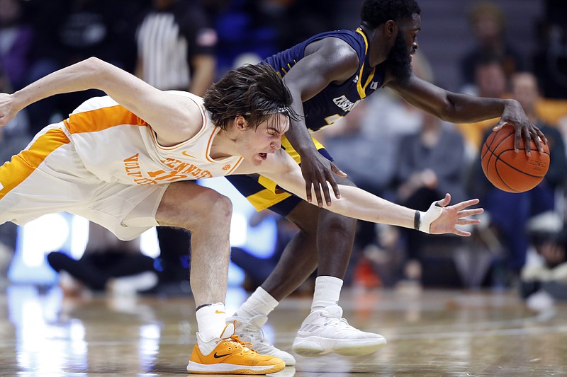 Tennessee forward John Fulkerson (10) attempts to steal the ball from Chattanooga guard David Jean-Baptiste (3) during the second half of an NCAA college basketball game Monday, Nov. 25, 2019, in Knoxville, Tenn. (AP Photo/Wade Payne)