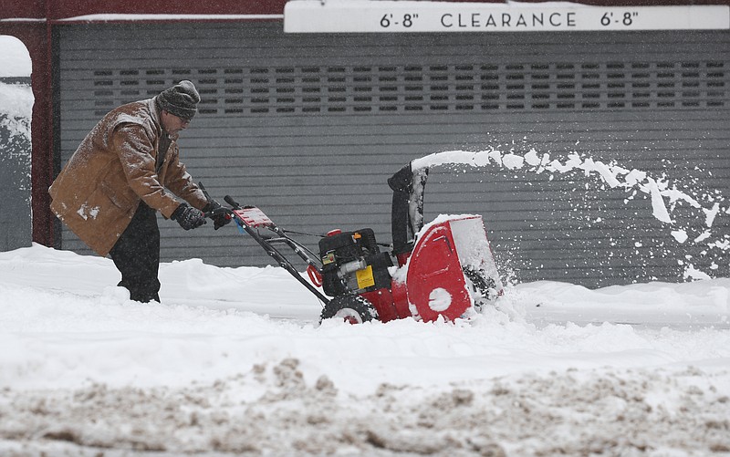 A maintenance man uses a snowblower to clear a sidewalk outside a condominium complex along Grant Street as a storm packing snow and high winds sweeps in over the region Tuesday, Nov. 26, 2019, in Denver. Stores, schools and government offices were closed or curtailed their hours while on another front, Thanksgiving Day travellers were forced to wrestle with snow-packed roads and flight delays or cancellations throughout the intermountain West. (AP Photo/David Zalubowski)