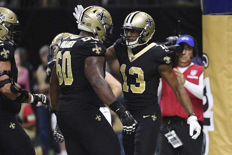 New Orleans Saints offensive guard Patrick Omameh (60) congratulates wide receiver Michael Thomas (13) after Thomas scored a touchdown, during the second half at an NFL football game against the Carolina Panthers, Sunday, Nov. 24, 2019, in New Orleans. (AP Photo/Bill Feig)