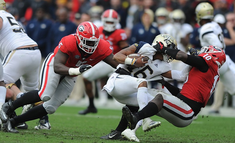 University of Georgia photo / Georgia defensive linemen Julian Rochester (5) and Malik Herring (10) make a stop during last November's 45-21 win over Georgia Tech, when the Yellow Jackets were in their 11th and final season of employing the triple-option offense under Paul Johnson.