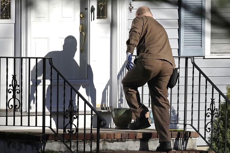 In this Nov. 26, 2019, file photo a UPS man delivers an Amazon package to a residence in North Andover, Mass. Amazon, Walmart and others are promising to deliver more of their goods in a day and this holiday season will be the first real test of whether they can make that happen. (AP Photo/Elise Amendola)