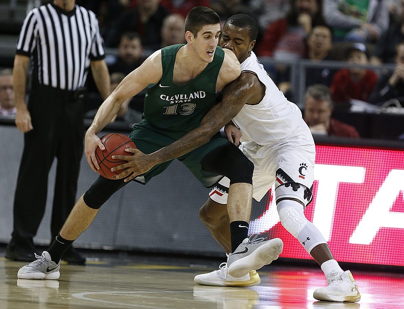 AP photo by Gary Landers / Stefan Kenic, left, tries to work around Cincinnati guard Jacob Evans while playing for Cleveland (Ohio) State during a game in December 2017. Kenic transferred to UTC in August, was cleared by the NCAA this week and made his Mocs debut Friday. He scored 15 points as UTC beat Alabama State.