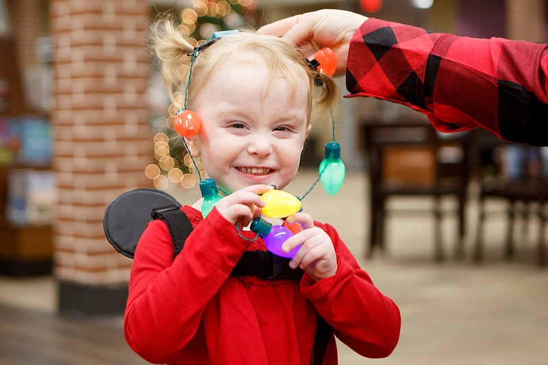Staff photo by C.B. Schmelter / Two-year-old Carley Cannon smiles as library manager Marshana Sharp puts a Christmas light necklace on her at the Dade County Public Library during Grand Illumination on Saturday, Nov. 30, 2019 in Trenton, Ga. The Grand Illumination event included ornament making, pictures with Santa, gifts and free hot chocolate inside the library and ended with the lighting of the Christmas trees downtown.