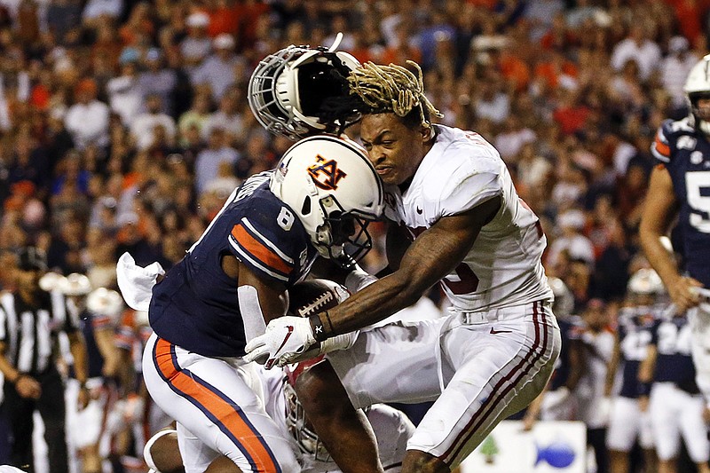 AP photo by Butch Dill / Alabama defensive back Xavier McKinney loses his helmet as Auburn running back Shaun Shivers plows through him for a touchdown during the second half of Saturday's Iron Bowl in Auburn, Ala.