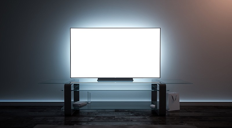 Blank white tv screen interior in darkness mockup, front view, 3d rendering. Empty telly plasma display in living room mock up. Clear smart panel monitor on glass shelf template. television tile tv channel remote tile / Getty Images
