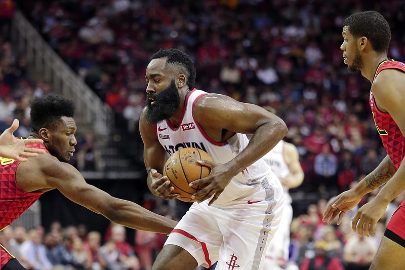 AP photo by Michael Wyke / Houston Rockets guard James Harden drives between Atlanta Hawks forward Bruno Fernando, left, and guard Tyrone Wallace during the third quarter of Saturday's game in Houston.