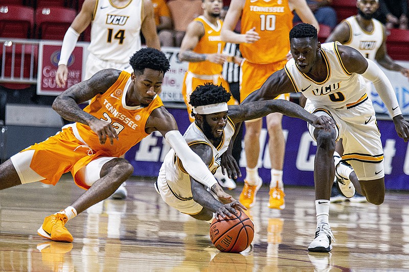 AP photo by Mark Wallheiser / From left, Tennessee guard Jordan Bowden and VCU's Issac Vann and De'Riante Jenkins battle for a loose ball in the first half of an Emerald Coast Classic consolation final on Saturday in Niceville, Fla.
