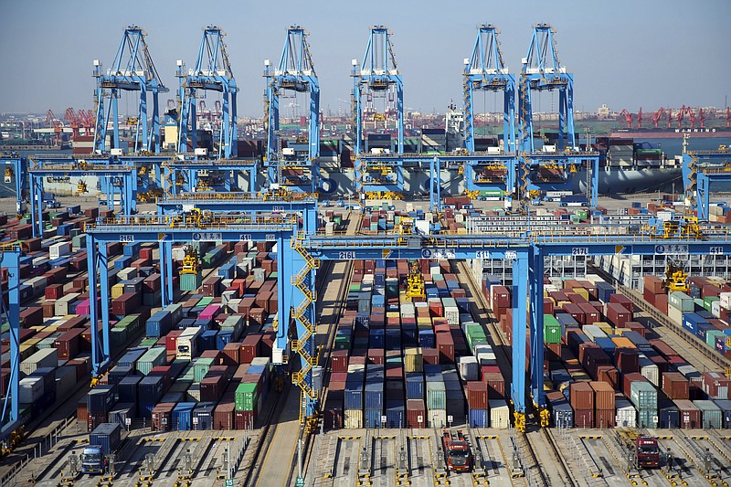 In this Thursday, Nov. 28, 2019, photo, trucks load containers at the automated container dockyard in Qingdao in east China's Shandong province. A Chinese official newspaper has reiterated, repeatedly, Beijing's demand that the U.S. roll back tariffs imposed by President Donald Trump's administration in exchange for a deal. The Communist Party newspaper Global Times ran several articles Monday, Dec. 2, 2019 that emphasized there would be no deal without a promise to phase out the tariffs imposed by Washington. (Chinatopix via AP)