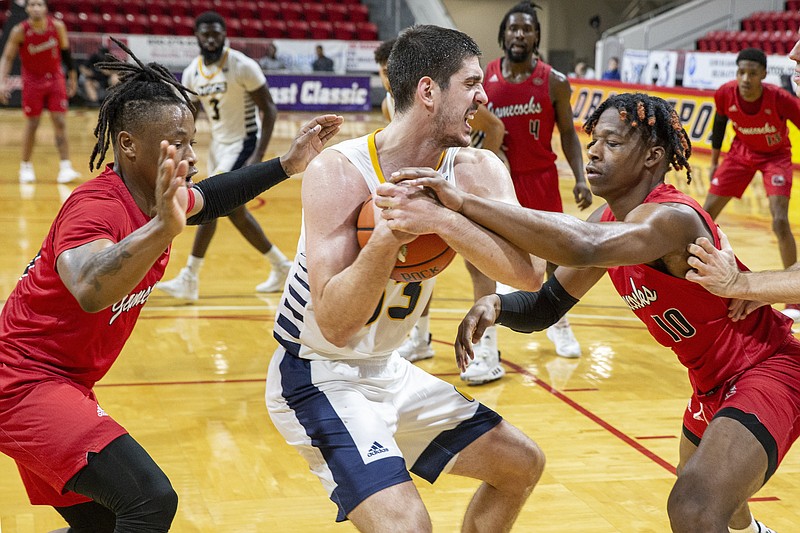 Jacksonville State guard Derek St. Hilaire (15), left, and forward Juwan Perdue (10) try to steal the ball from Chattanooga forward Stefan Kenic (33) in the closing seconds seconds in an NCAA college basketball game at the Emerald Coast Classic in Niceville, Fla., Saturday, Nov. 30, 2019. (AP Photo/Mark Wallheiser)