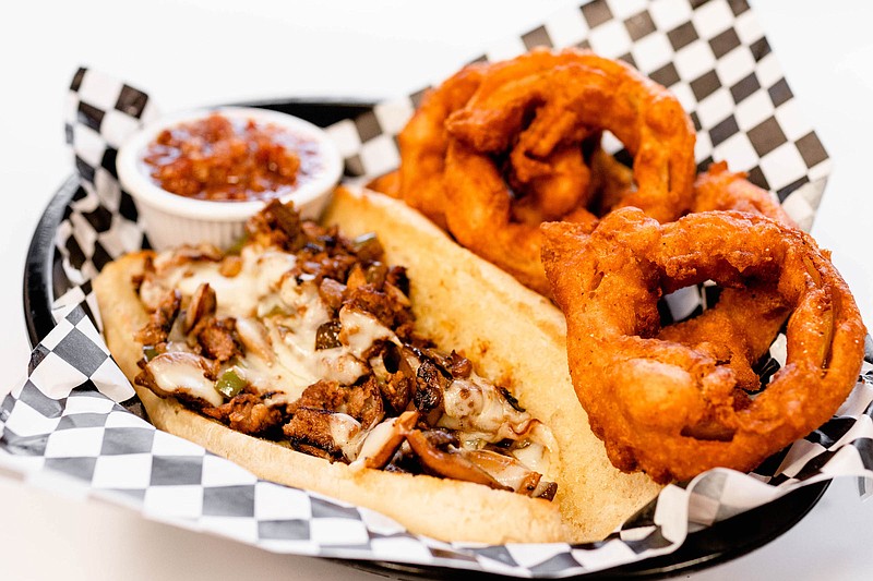 Photo by Chloe Goodman / The Philly cheesesteak comes with hand-battered onion rings and bacon jam for dipping.