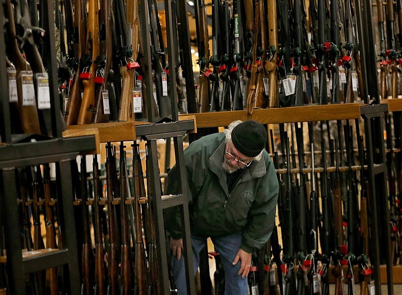 FILE - In this Nov. 29, 2019, file photo, a man looks at the shotgun section of Cabela's while shopping on Black Friday in Hazelwood, Mo. (Christian Gooden/St. Louis Post-Dispatch via AP)

