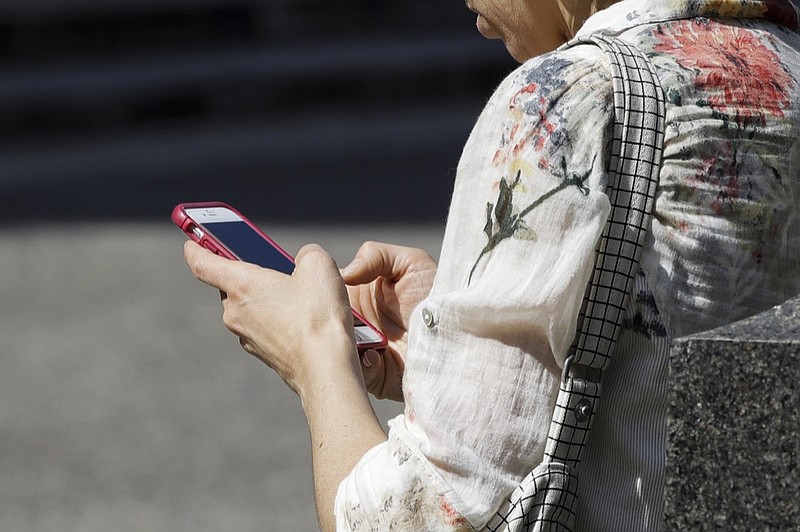FILE - In this April 8, 2019, file photo, a woman browses her smartphone in Philadelphia. Accidental cuts and bruises to the face, head and neck from cellphones are sending increasing numbers of Americans to the emergency room, according to a study that estimates 76,000 cases over nine years. (AP Photo/Matt Rourke, File)


