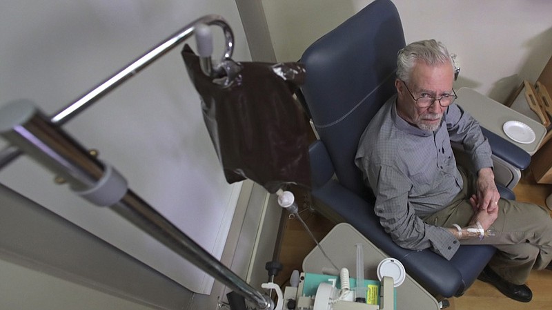 In this Nov. 22, 2019, photo, Charles Flagg, who is stricken with Alzheimer's disease, receives the contents of an intravenous bag while participating in a study on the drug Aducanumab at Butler Hospital in Providence, R.I. New results were released on the experimental medicine whose maker claims it can slow the decline of Alzheimer's disease, the most common form of dementia. (AP Photo/Charles Krupa)


