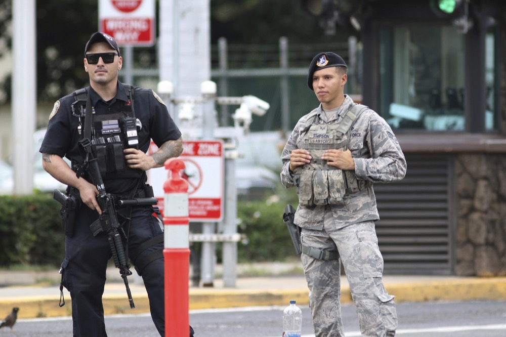 Security stand outside the main gate at Joint Base Pearl Harbor-Hickam Wednesday, Dec. 4, 2019, in Honolulu. A shooting at Pearl Harbor naval shipyard in Hawaii left at least one person injured Wednesday, military and hospital officials said. Joint Base Pearl Harbor-Hickam spokesman Charles Anthony confirmed that there was an active shooting at Pearl Harbor naval shipyard. The military tweeted that it began around 2:30 p.m. Queen's Medical Center spokesperson Cedric Yamanaka said the hospital was treating one patient but didn't give e details on their condition. (AP Photo/Caleb Jones)