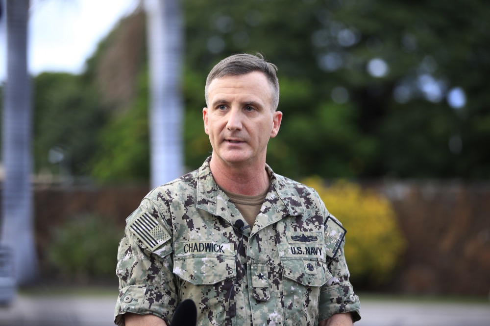 US Navy Rear Adm. Robb Chadwick speaks to the media at the main gate at Joint Base Pearl Harbor- Hickam Wednesday, Dec. 4, 2019, in Honolulu. A shooting at Pearl Harbor naval shipyard in Hawaii left at least one person injured Wednesday, military and hospital officials said. Joint Base Pearl Harbor-Hickam spokesman Charles Anthony confirmed that there was an active shooting at Pearl Harbor naval shipyard. The military tweeted that it began around 2:30 p.m. Queen's Medical Center spokesperson Cedric Yamanaka said the hospital was treating one patient but didn't give e details on their condition. (AP Photo/Marco Garcia)