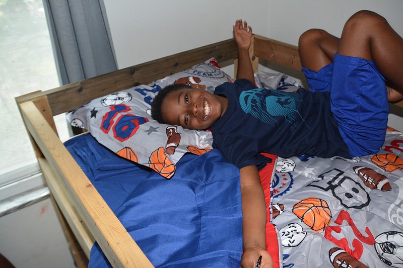 A happy recipient lays down on his new bed built by Sleep in Heavenly Peace. It was the 400th bed built and delivered by the Chattanooga chapter. / Photo contributed by Sleep in Heavenly Peace