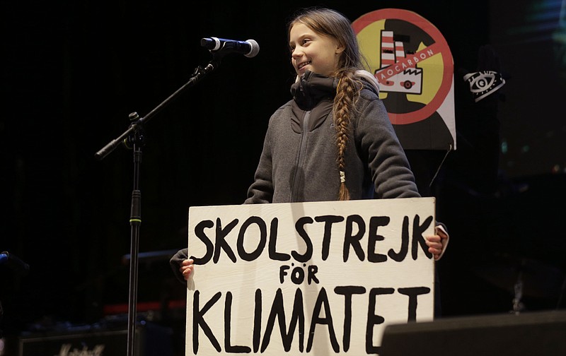 Climate activist Greta Thunberg speaks to assistants during a demonstration in Madrid, Friday Dec. 6, 2019. Thunberg arrived in Madrid Friday to join thousands of other young people in a march to demand world leaders take real action against climate change. Banner reads "School strike for climate". (AP Photo/Andrea Comas)