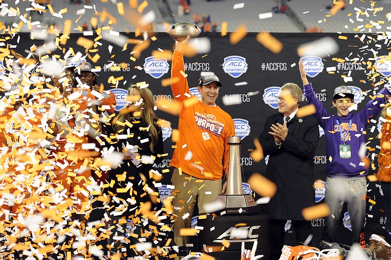 Clemson football coach Dabo Swinney, center, celebrates after the Tigers beat Virginia 62-17 in the Atlantic Coast Conference championship game Saturday night in Charlotte, N.C. / AP Photo by Mike McCarn