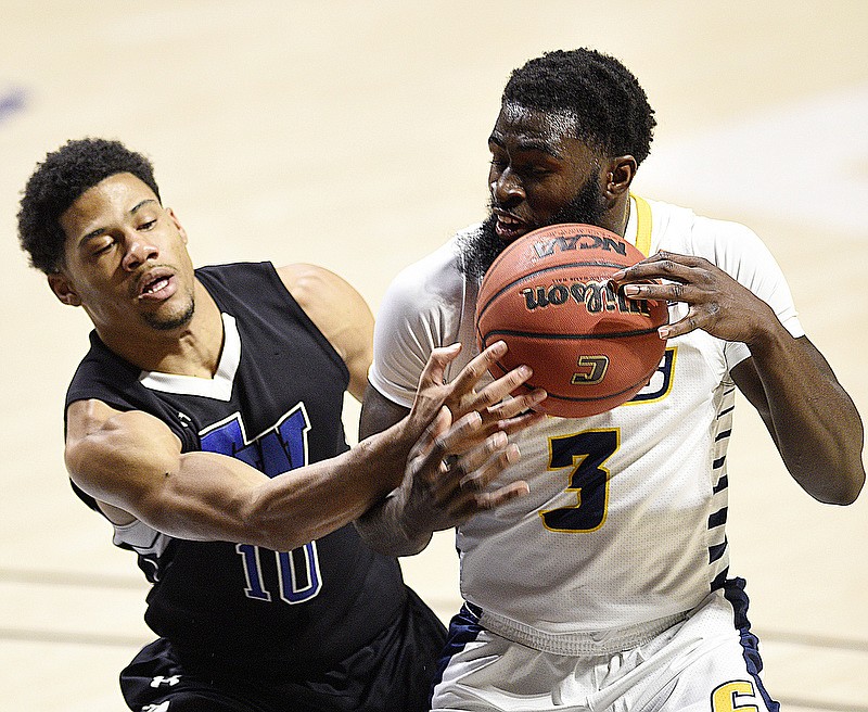 Tennessee Wesleyan's Cameron Montgomery, left, who played at East Hamilton High School, tries to steal the ball from UTC's David Jean-Baptiste during Sunday afternoon's game at McKenzie Arena. UTC raced to a 12-0 lead and won 99-51 against the NAIA program from Athens. / Staff photo by Robin Rudd