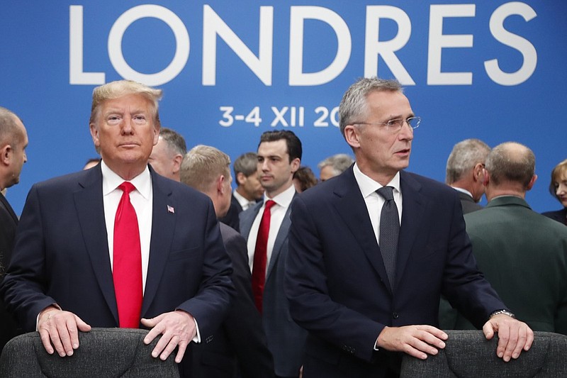 In this Dec. 4, 2019, photo, U.S. President Donald Trump and NATO Secretary General Jens Stoltenberg wait to take their seats prior to a NATO leaders meeting at The Grove hotel and resort in Watford, Hertfordshire, England. Three years into the Trump presidency, America's new place in the world is coming into focus, with influence waning from NATO meeting rooms to the Middle East to the capital cities of key allies. And in many ways, that's just fine with the White House. (AP Photo/Frank Augstein)