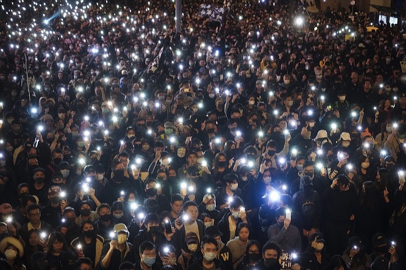 Pro-democracy protesters flash their smartphones lights as they gather on a street in Hong Kong, Sunday, Dec. 8, 2019. Thousands of people took to the streets of Hong Kong on Sunday in a march seen as a test of the enduring appeal of an anti-government movement about to mark a half year of demonstrations. (AP Photo/Vincent Yu)

