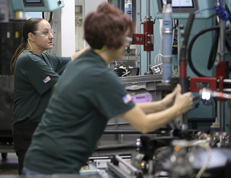 File photo by C.B. Schmelter / In this 2017 photo, line lead employee Amber Hixson, left, works at Mann+Hummel plant in Dunlap, which will undergo a $15 million expansion to boost production and add 50 jobs