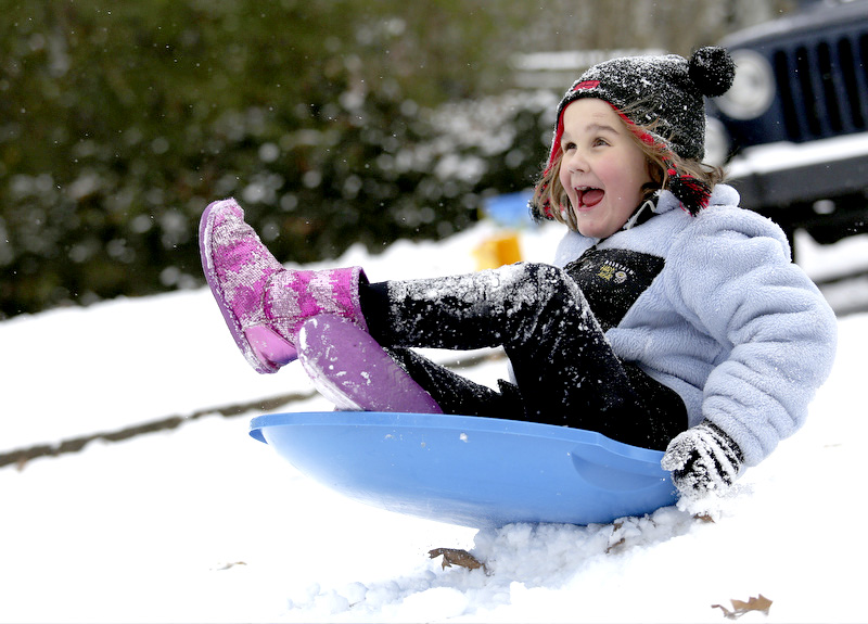 Arden Beach plays in the snow with her father and friends on Tuesday, January 28, 2014, in Chattanooga, Tenn. Snow blanked the ground all over the city.